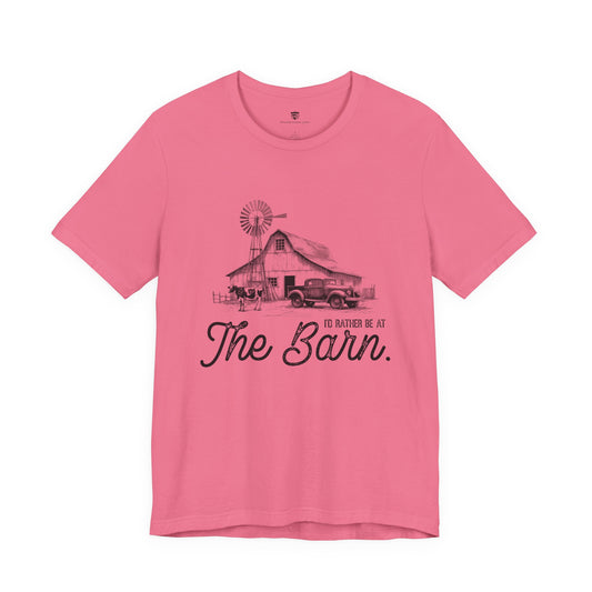 Pink t-shirt with a graphic of a barn and truck, and text 'I'd Rather be at The Barn'