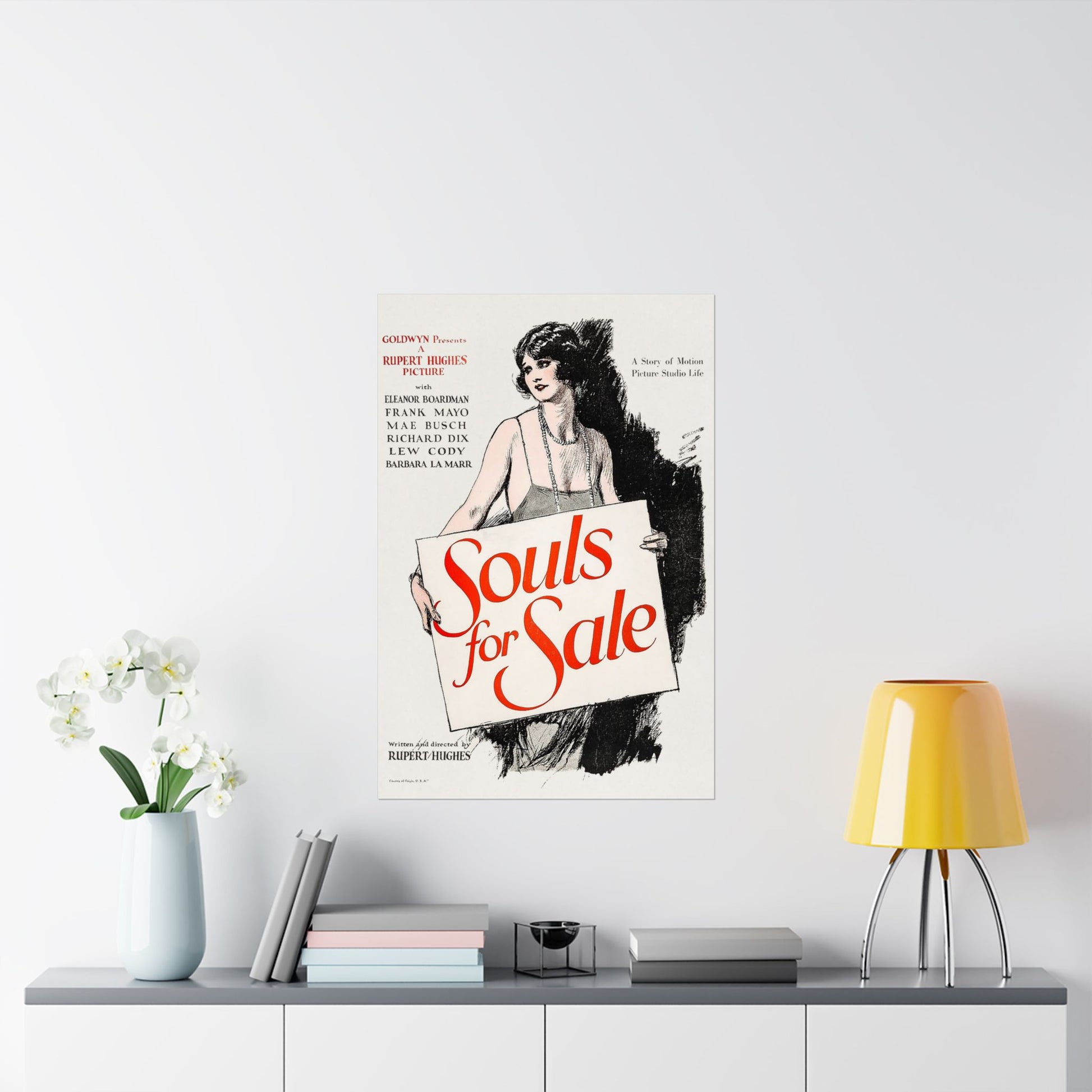 Vintage movie poster for 'Souls for Sale' on a wall above a shelf with decor items.
