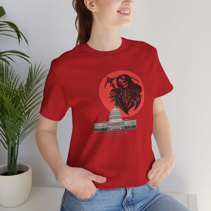 Person wearing a red t-shirt with a graphic design of a skeleton holding an axe over a building, standing indoors.