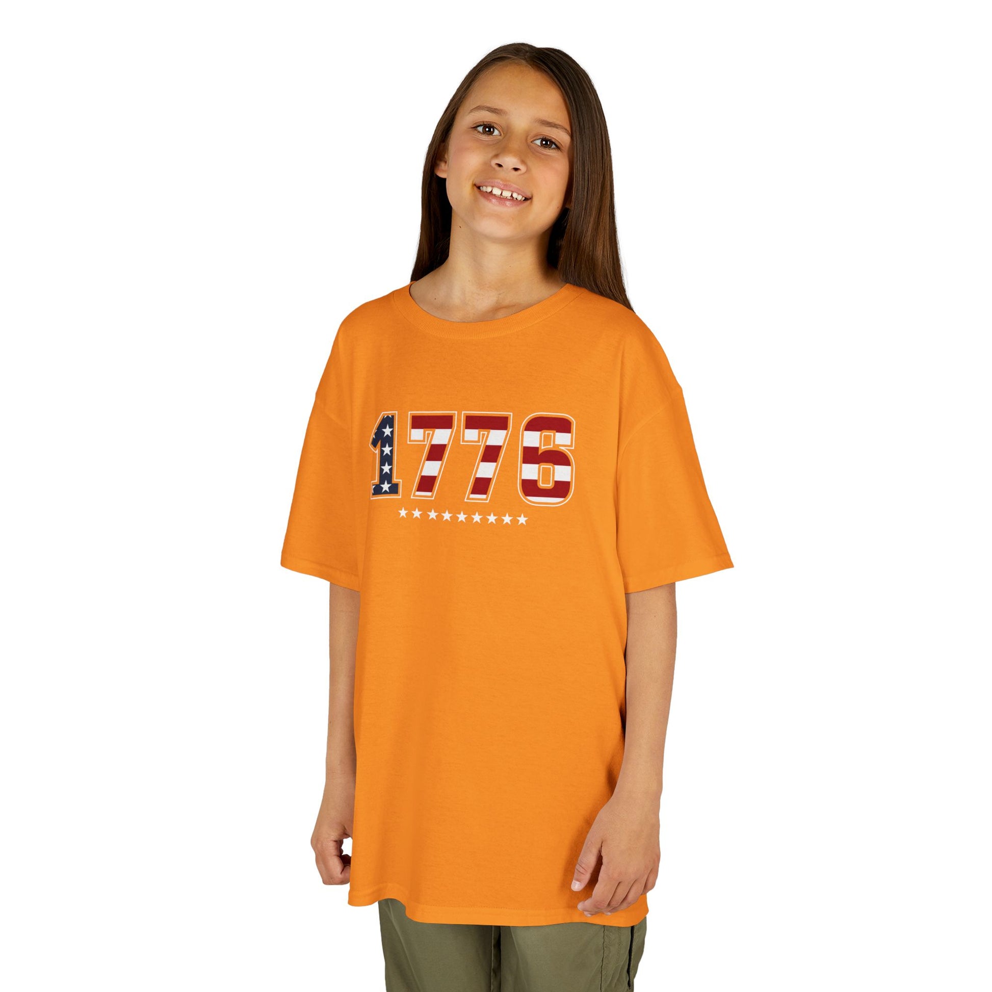 Child wearing an orange t-shirt with '1776' design on a white background