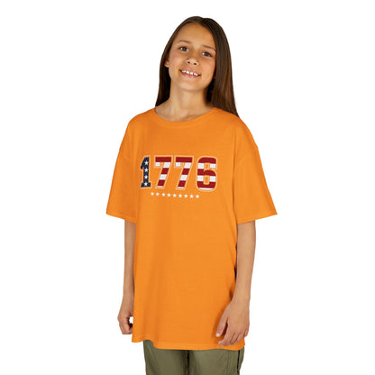 Child wearing an orange t-shirt with '1776' design on a white background