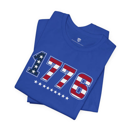 Blue t-shirt with '1776' design featuring stars and stripes on a white background