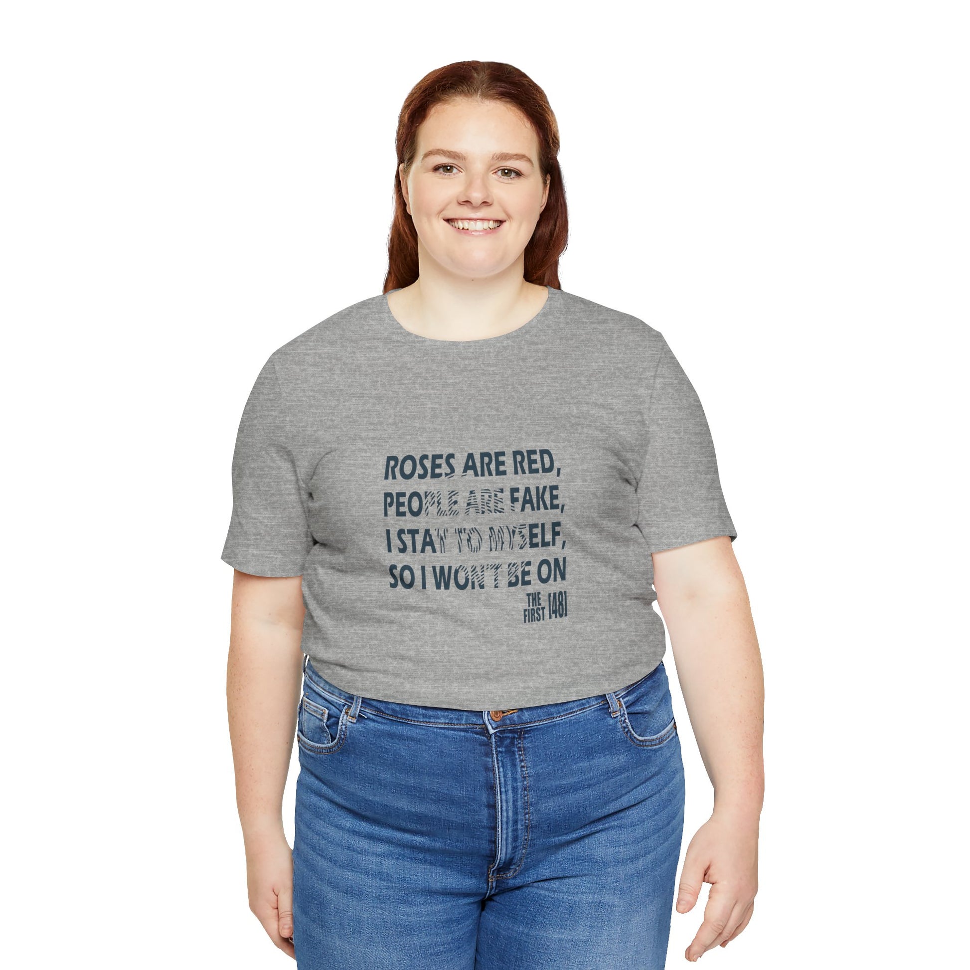 Person wearing a gray t-shirt with text and blue jeans on a white background
