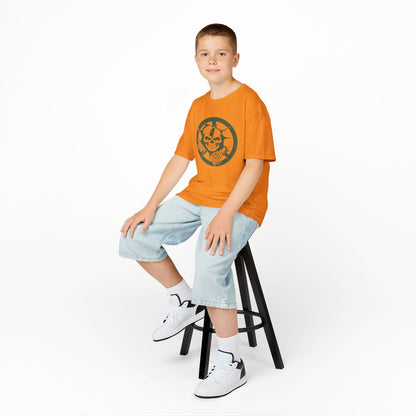 Child sitting on a stool wearing an orange t-shirt with text and graphics, light blue shorts, and white sneakers.
