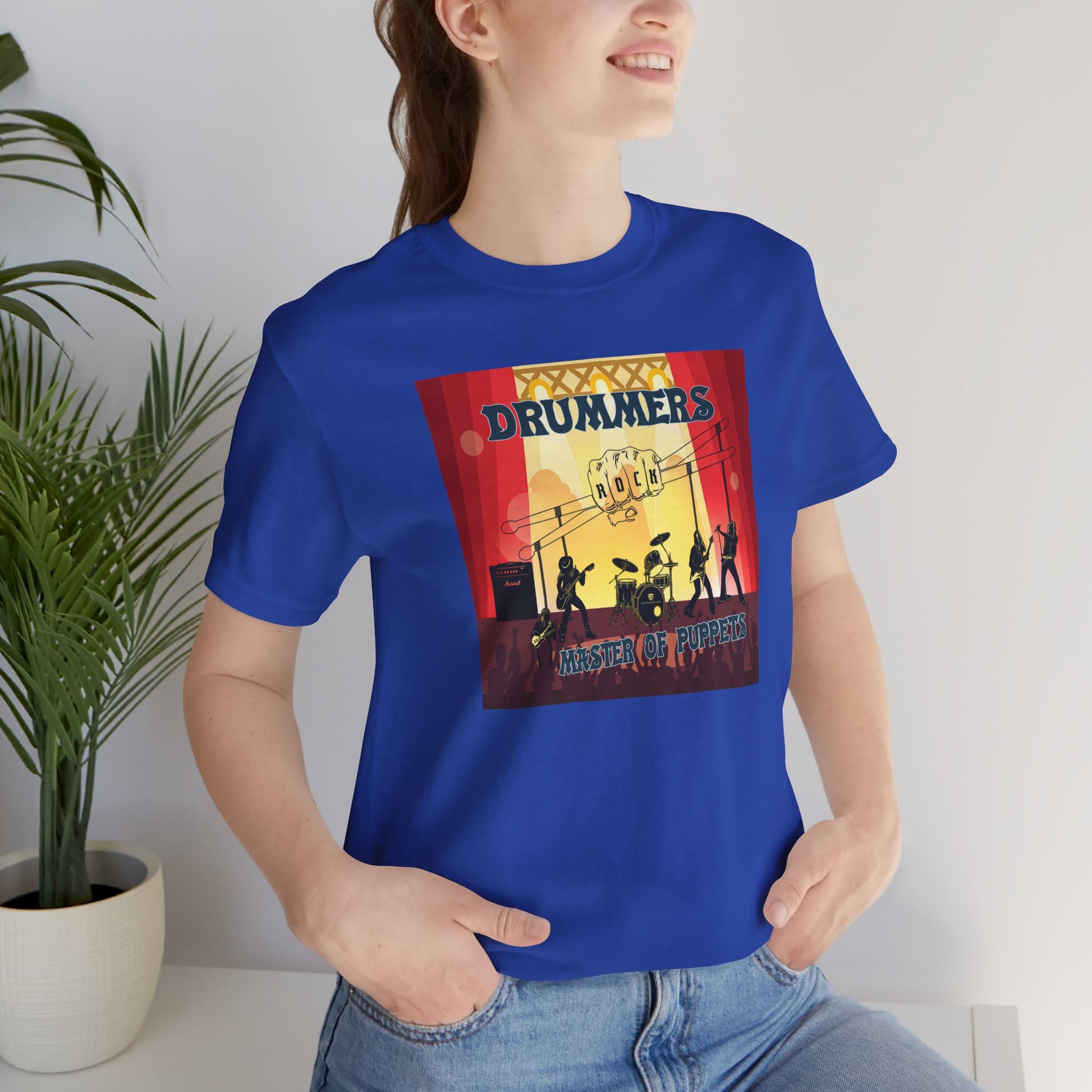 Person wearing a blue t-shirt with a graphic design of drummers and text.
