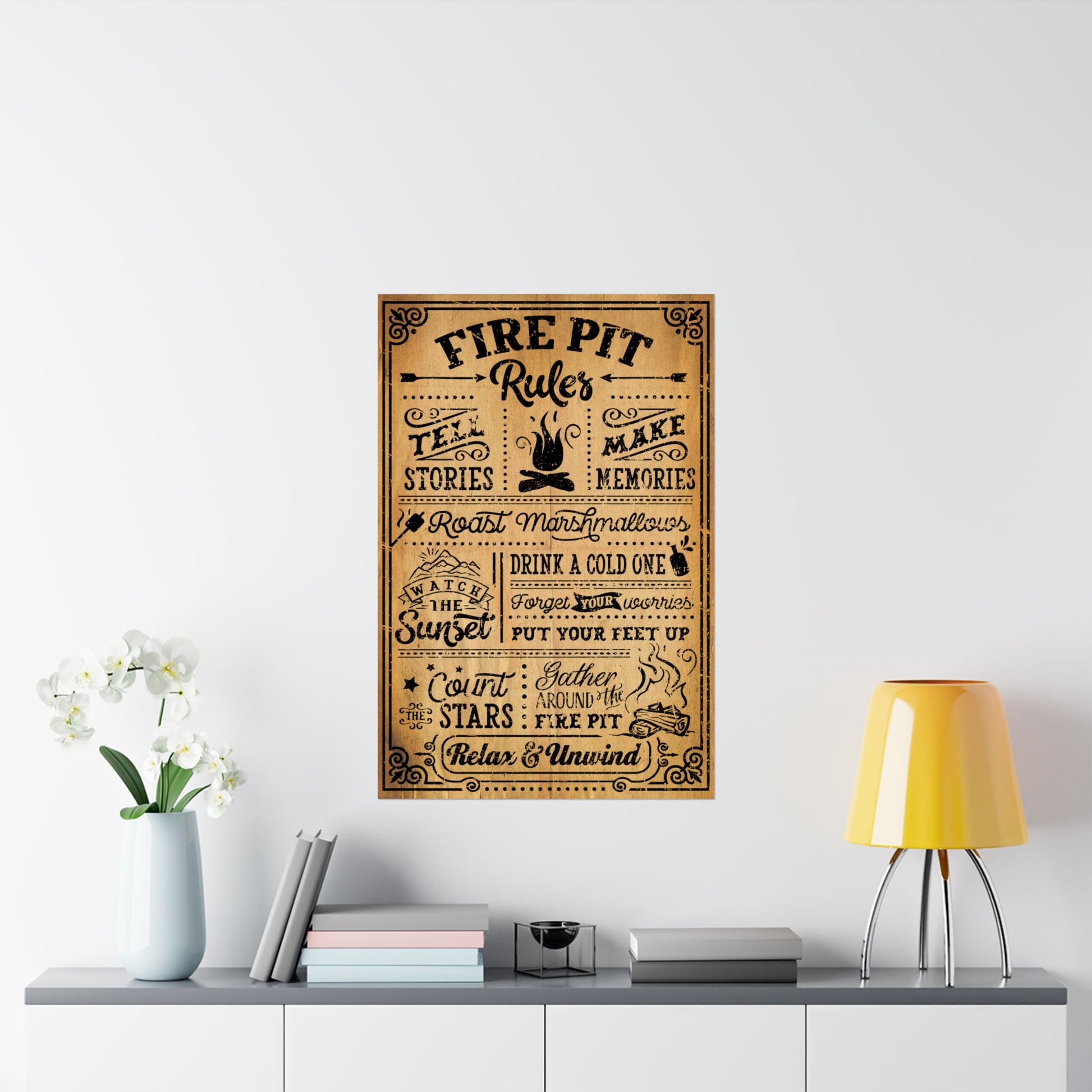 Decorative poster with text on a wall above a table with a lamp and books.