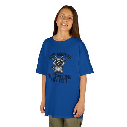 Child wearing a blue t-shirt with a raccoon graphic and text on a white background