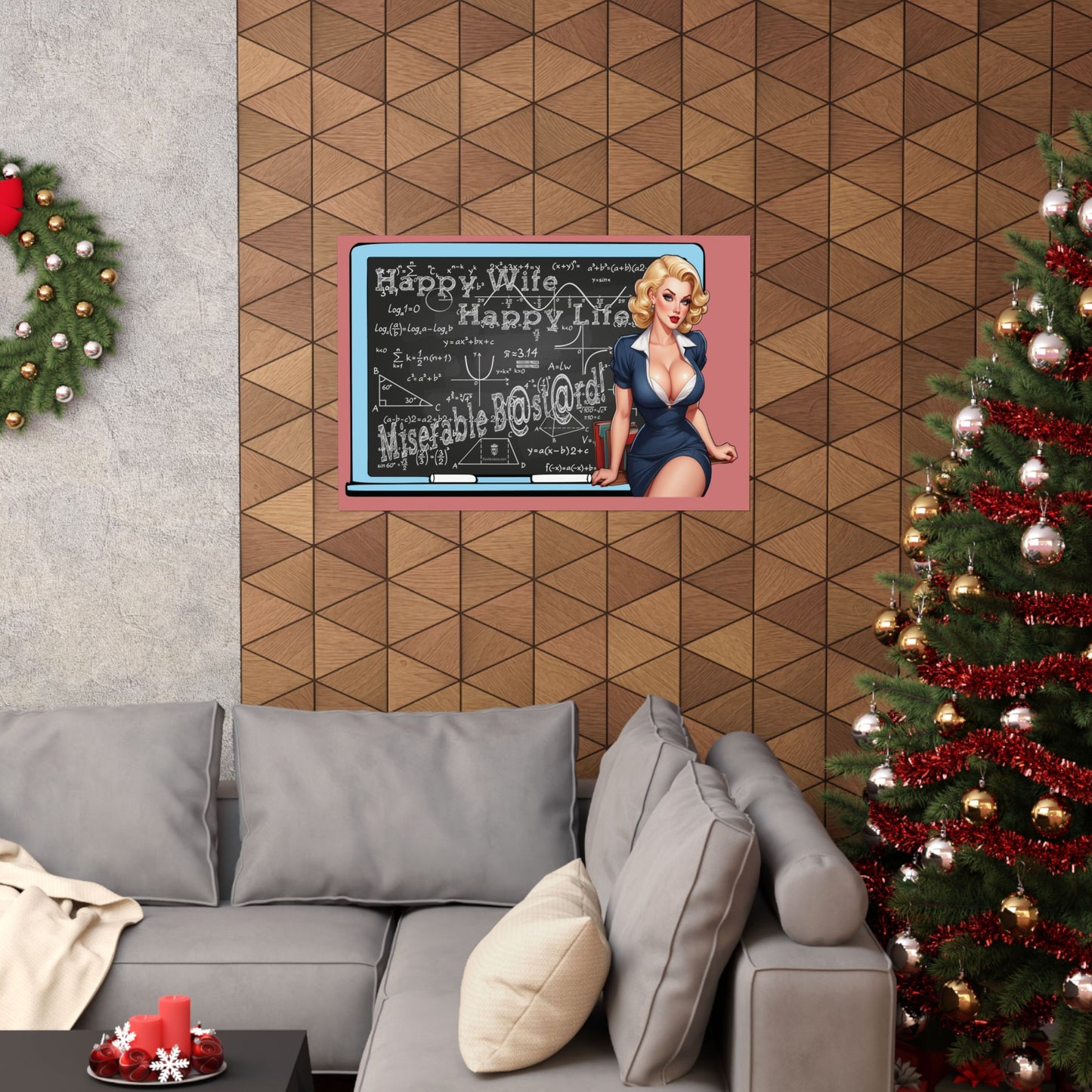 A framed wall art print featuring a vintage-style blonde woman in a blue dress standing in front of a chalkboard with holiday greetings, displayed above a gray sectional sofa in a decorated living room with a Christmas tree and wreath.