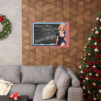 A framed wall art print featuring a vintage-style blonde woman in a blue dress standing in front of a chalkboard with holiday greetings, displayed above a gray sectional sofa in a decorated living room with a Christmas tree and wreath.