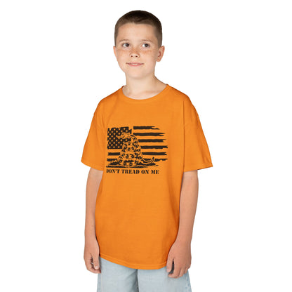 Child wearing an orange t-shirt with a graphic design on a white background