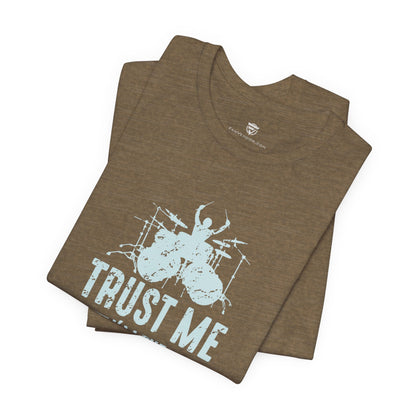 Green t-shirt with drum set graphic and 'Trust Me' text on a white background