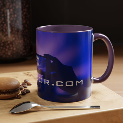 Blue mug with a brand logo on a wooden surface with coffee beans and a spoon.