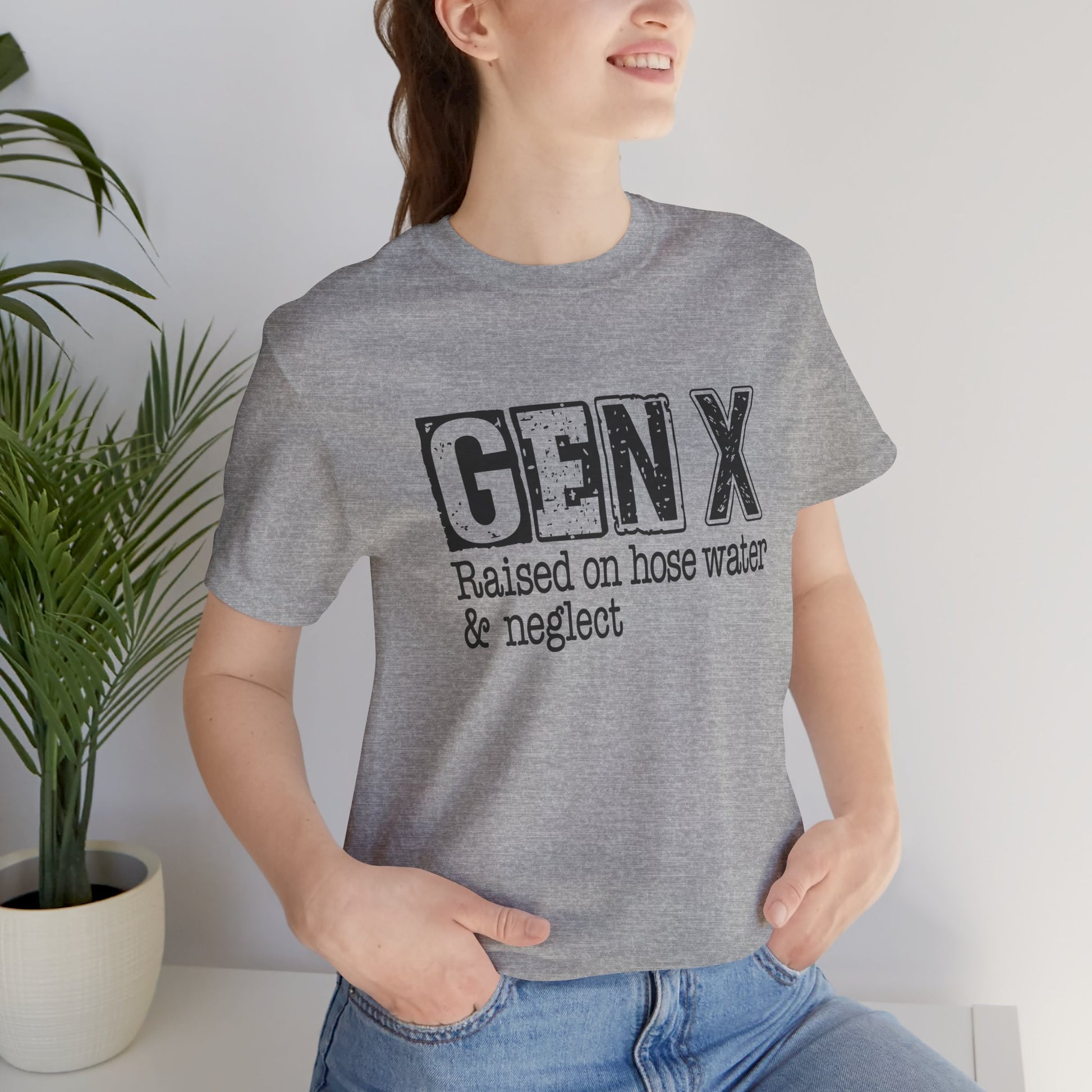 Person wearing a gray t-shirt with 'GENX Raised on hose water & neglect' text, standing indoors.
