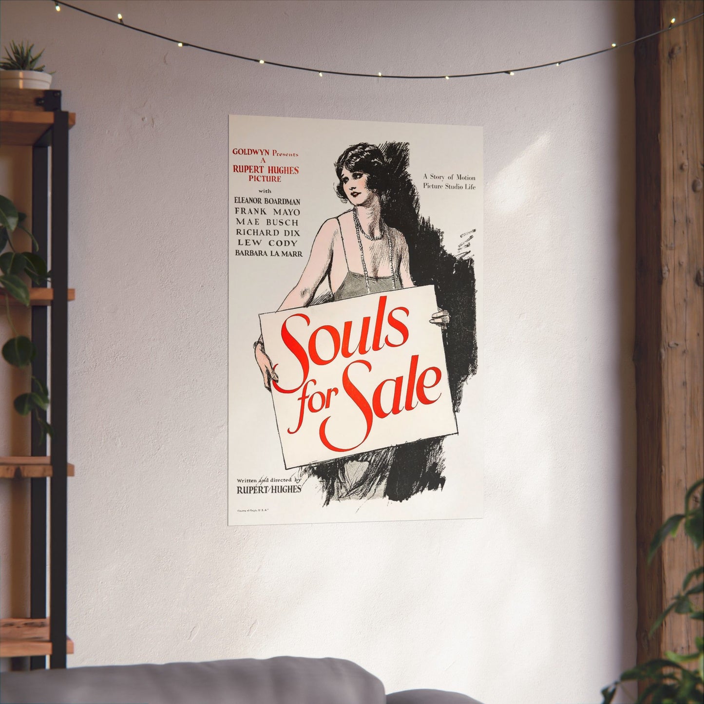 Movie poster for 'Souls for Sale' on a wall with decorative lights and plants.