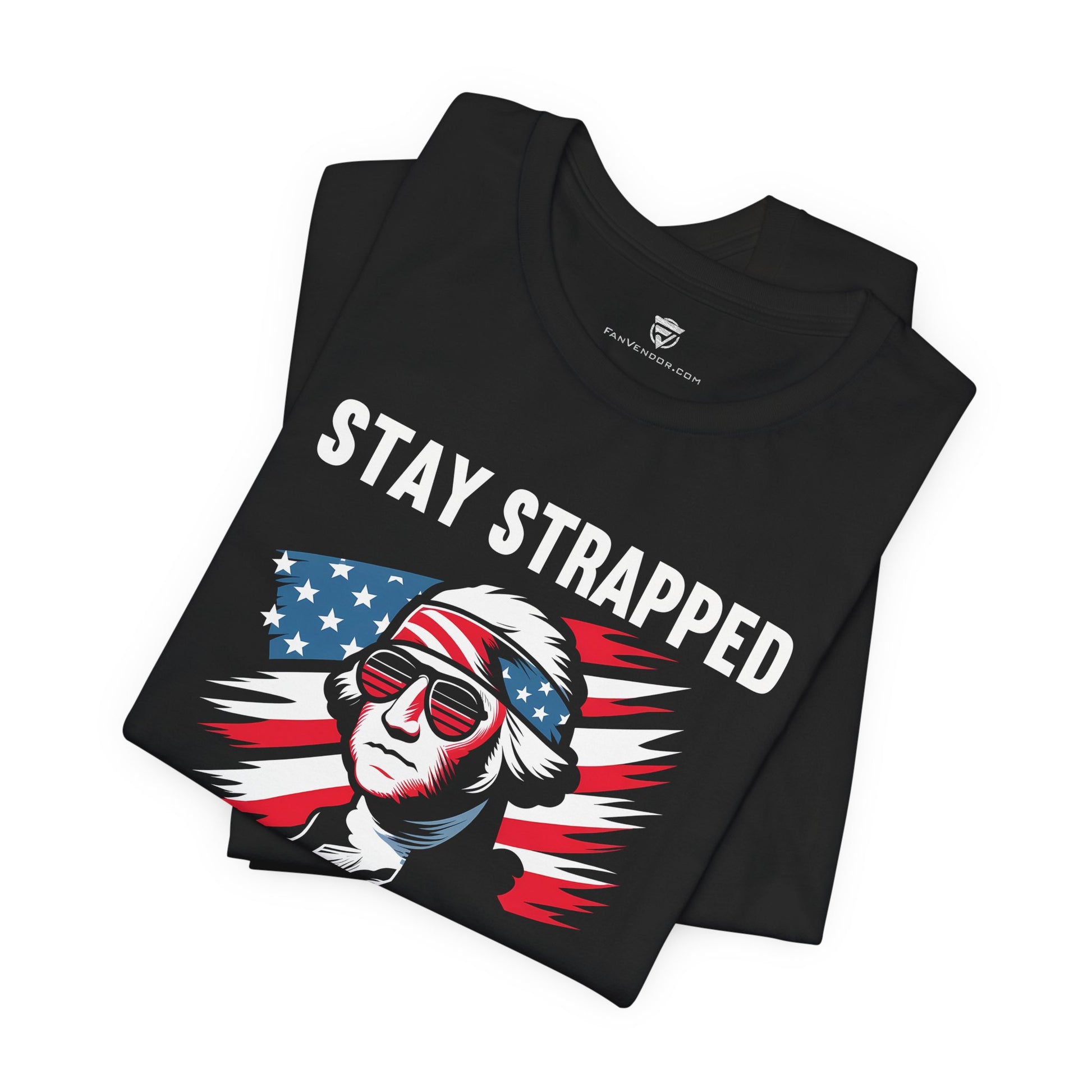 Black t-shirt with 'Stay Strapped' graphic design featuring an American flag and a person's head, folded on a white background.