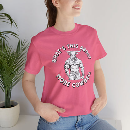 Person wearing a pink t-shirt with a graphic and text, standing indoors next to a plant.