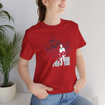Person wearing a red t-shirt with graphic design, sitting indoors next to a plant.