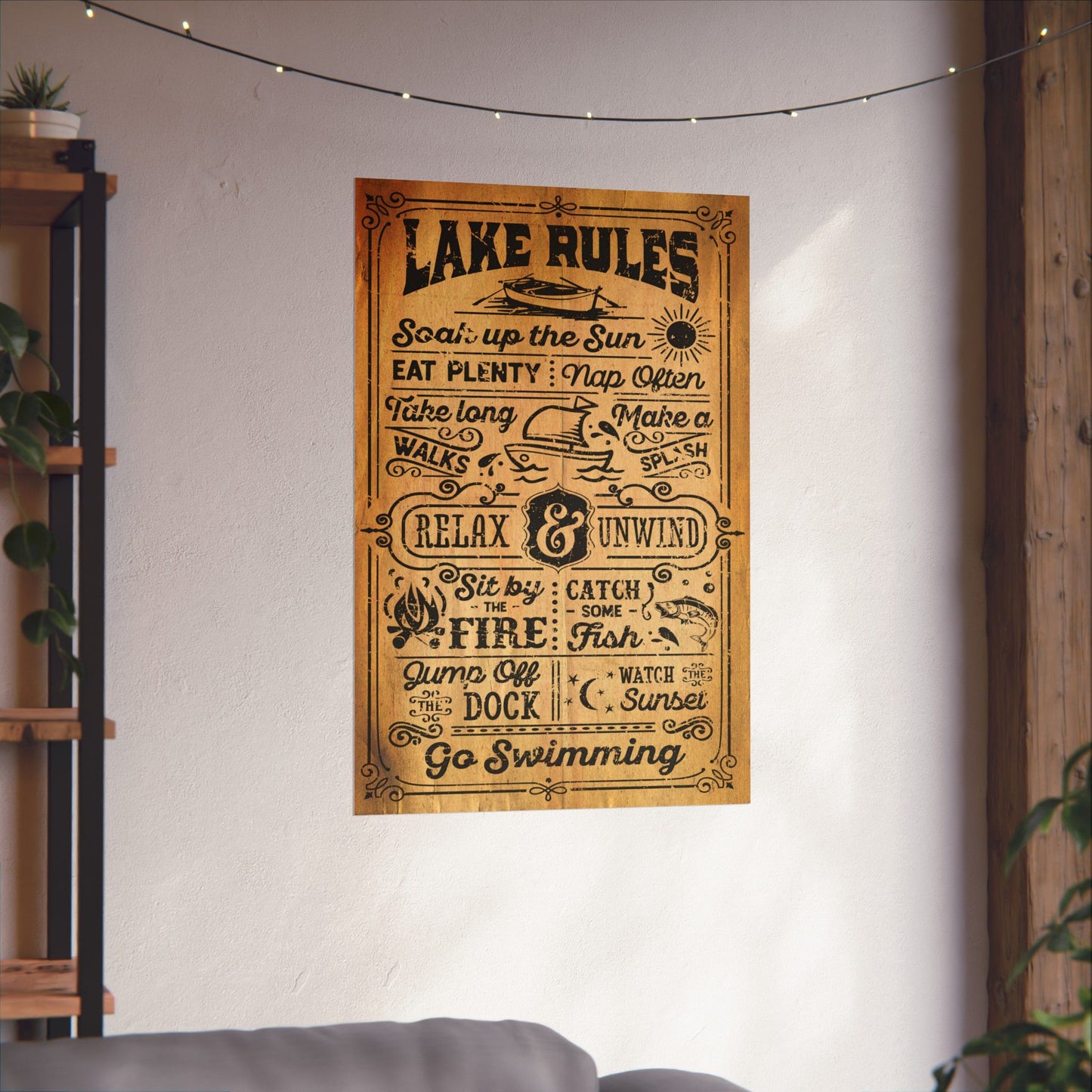 Wooden sign with 'Lake Rules' on a wall in a room with a couch and plants.
