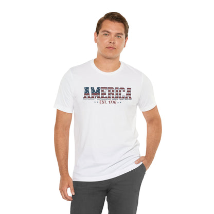 Man wearing a white t-shirt with 'AMERICA EST. 1776' text on a white background