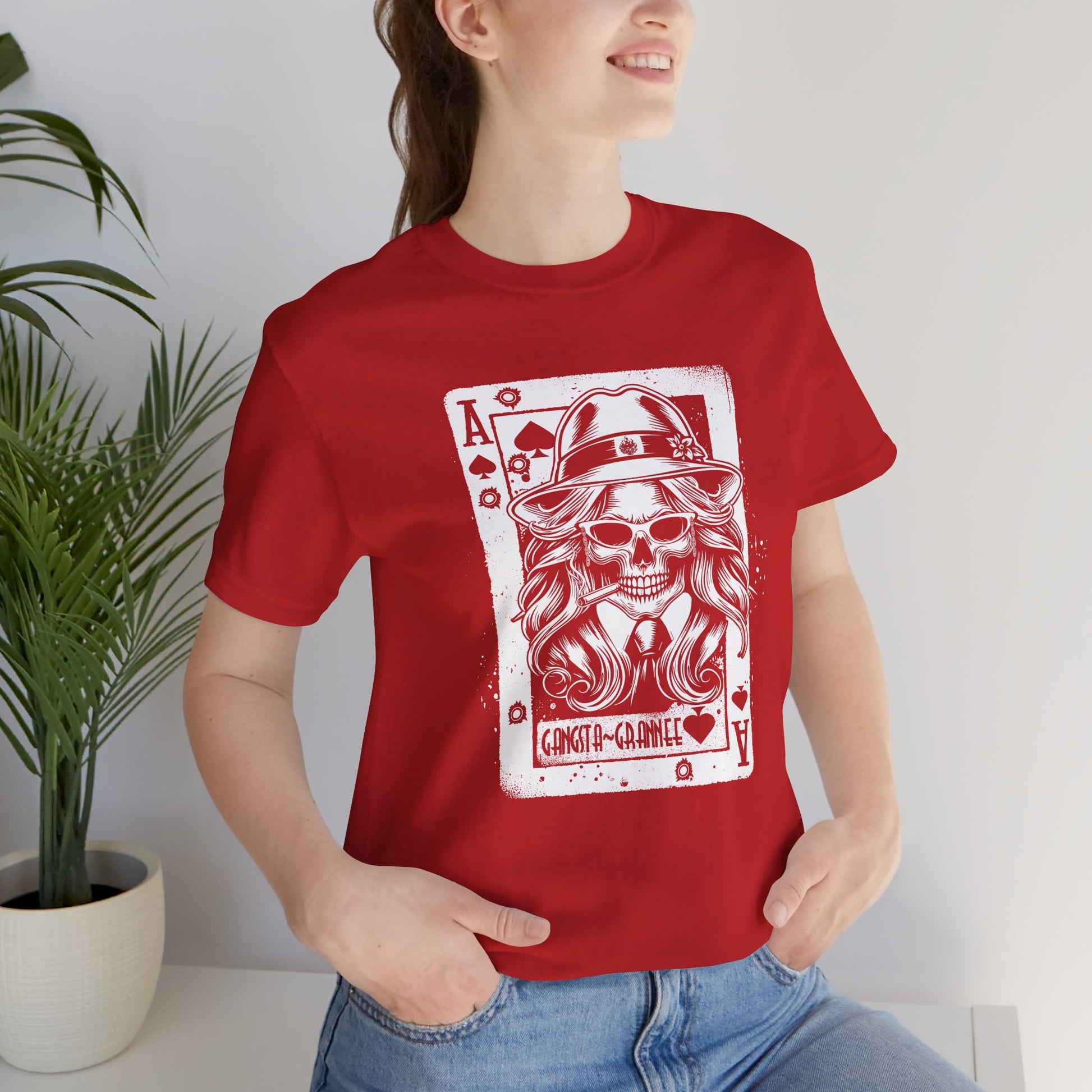 Person wearing a red t-shirt with a graphic design of a skeleton playing card.