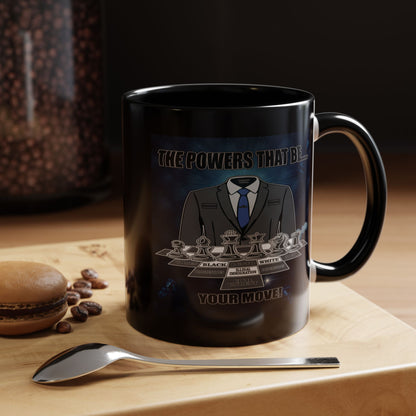 A black ceramic coffee mug with a custom chess-themed graphic, displayed on a wooden surface next to a spoon and a macaron with coffee beans. The mug features a chess knight in a suit and the text.
