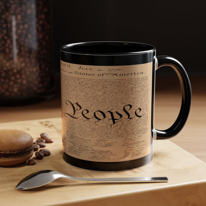 Mug with a design resembling the U.S. Constitution on a wooden surface with coffee beans and a spoon.
