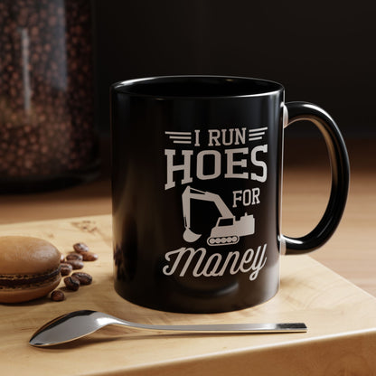 Black mug with offensive text on a wooden surface with coffee beans and a spoon.