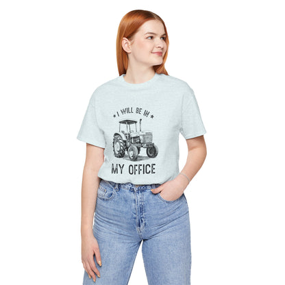 Person wearing a light blue t-shirt with a tractor graphic and text