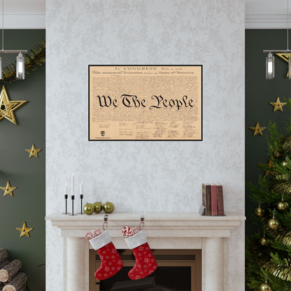 Framed document with 'We The People' on a wall above a fireplace with Christmas stockings and decorations.