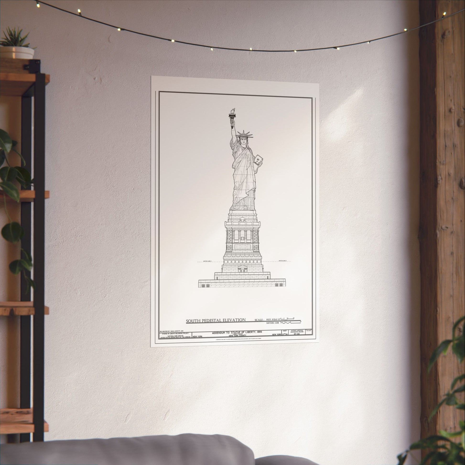 Framed blueprint of the Statue of Liberty on a wall in a room with a shelf and plants.