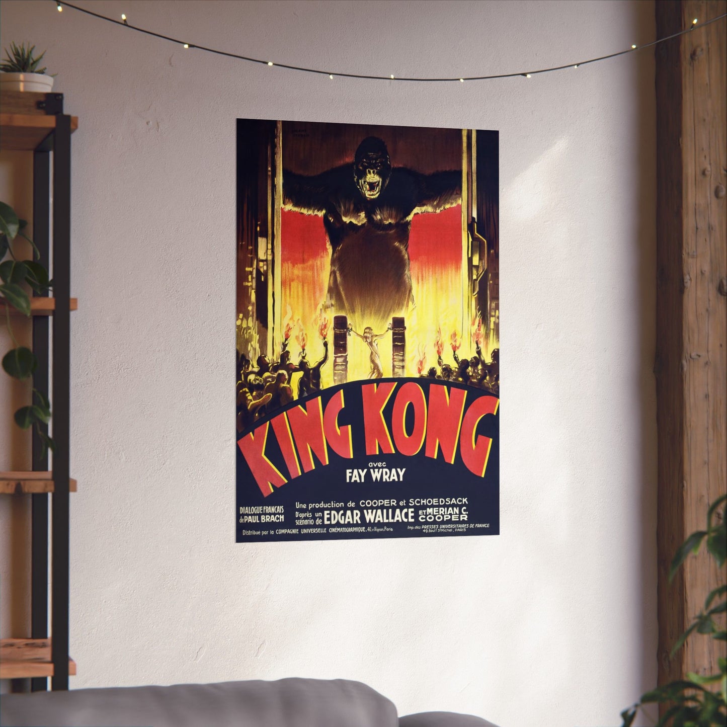 King Kong movie poster on a wall in a room with a shelf and plants.