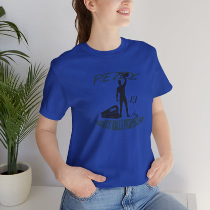 Person wearing a blue t-shirt with a graphic design in a room with a plant.