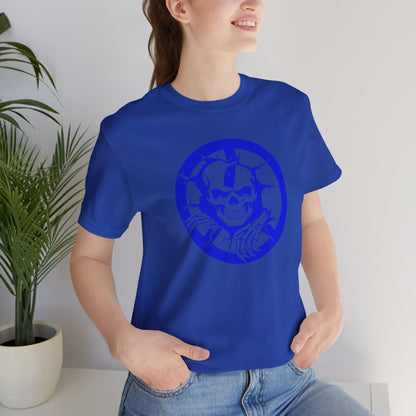 Person wearing a blue t-shirt with a skull design in a room with a plant.