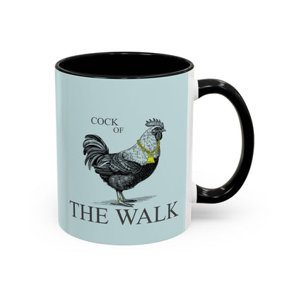 Mug with rooster illustration and 'Cock of the Walk' text on a light blue background
