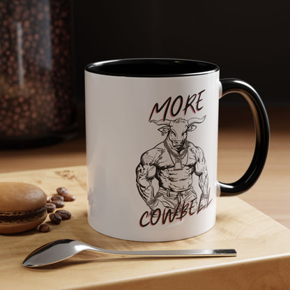 Mug with a graphic of a muscular figure and text on a wooden surface with coffee beans and a spoon.