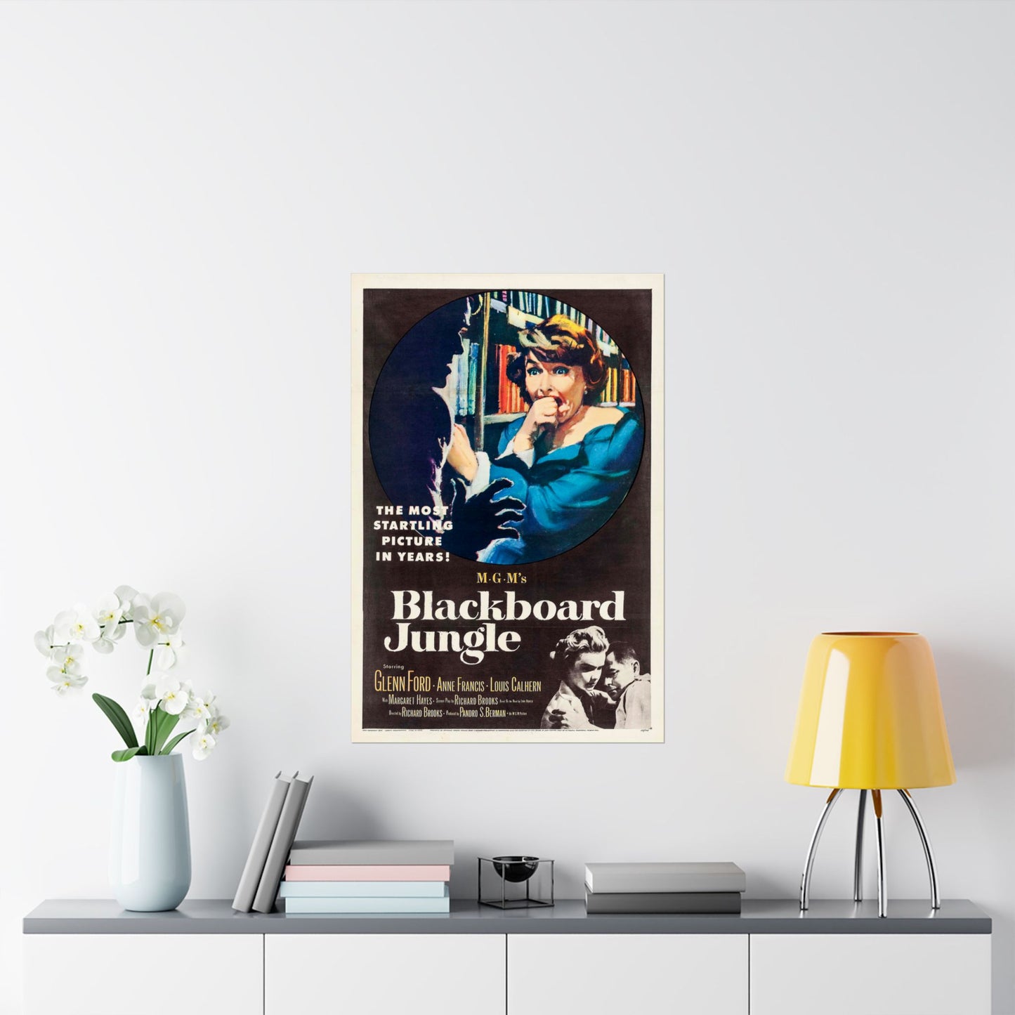 Vintage movie poster for 'Blackboard Jungle' on a wall above a shelf with decor items.