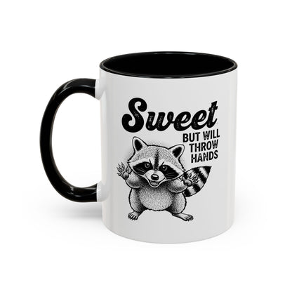 White mug with black interior and handle, featuring a raccoon illustration and text.