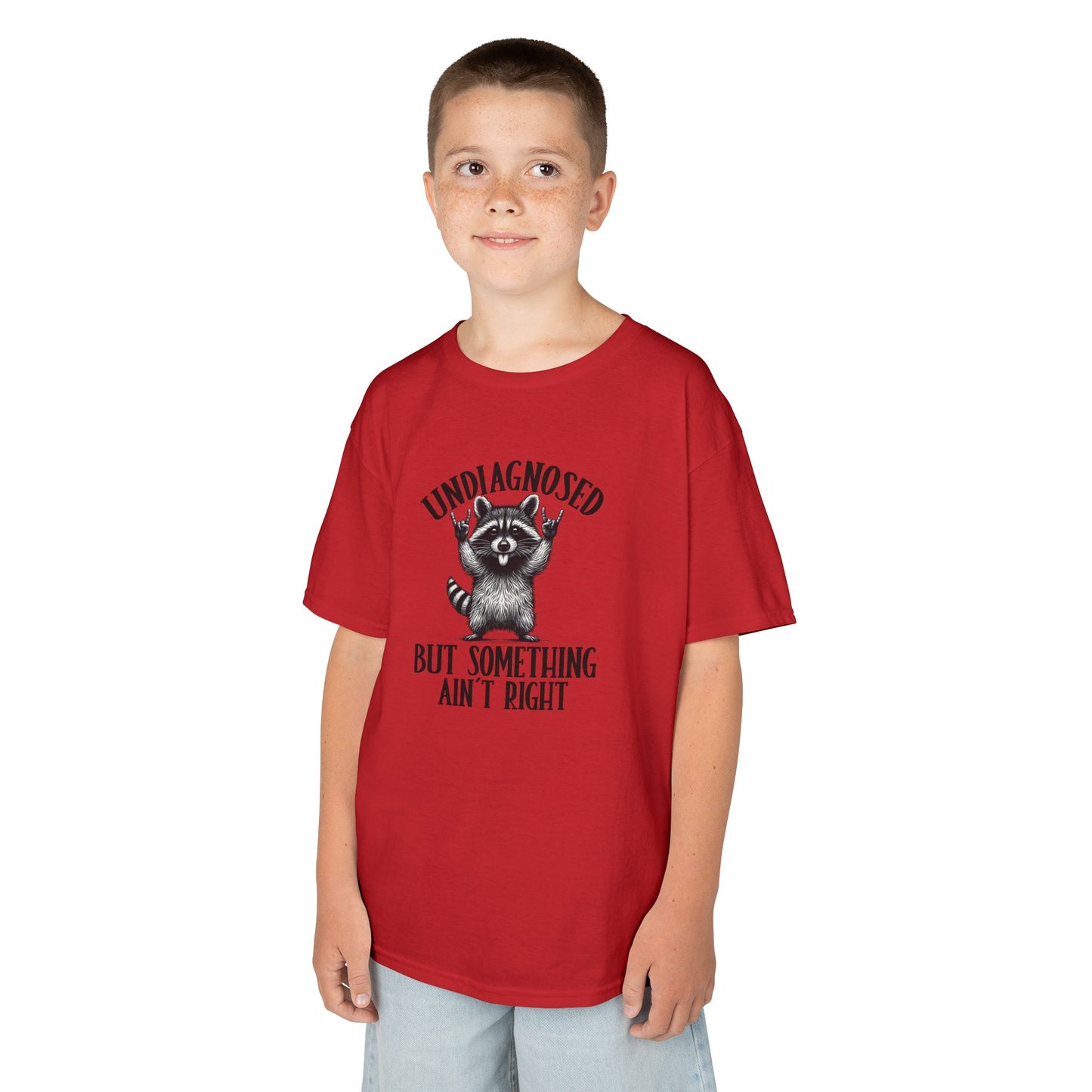 Child wearing a red t-shirt with a raccoon graphic and text on a white background