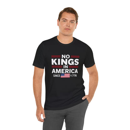 Man wearing a black t-shirt with 'No Kings in America' text and an American flag graphic.