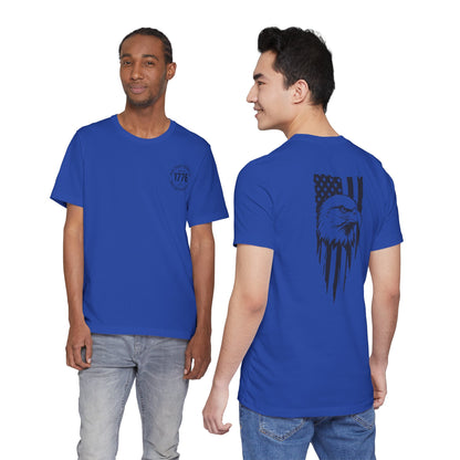 Two people wearing blue t-shirts with a design on the front and back, respectively.