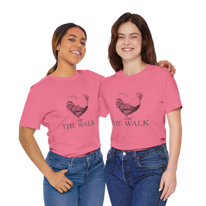 Two women wearing pink t-shirts with a rooster graphic and text 