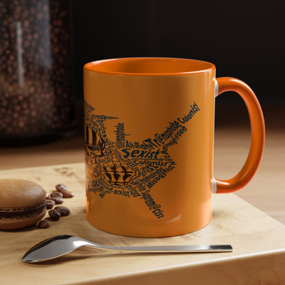 Orange mug with star design and text on a wooden surface with coffee beans and a spoon.