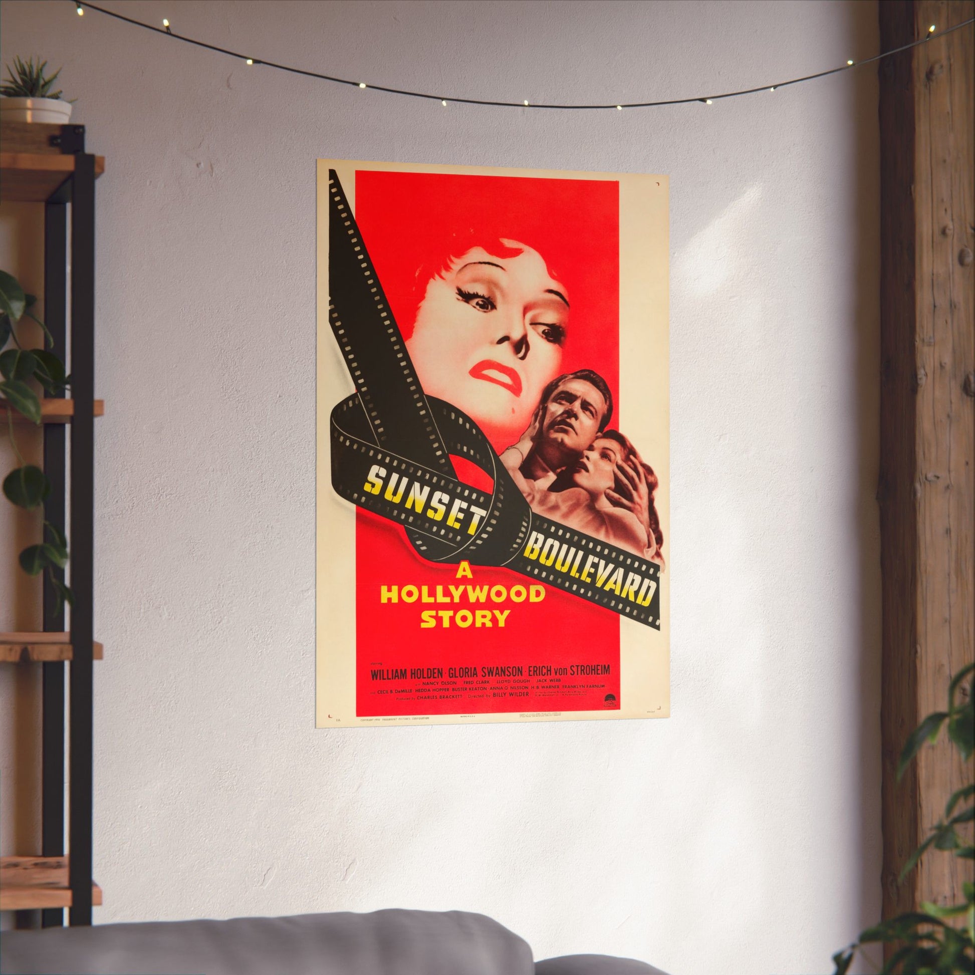 Movie poster for 'Sunset Boulevard' on a wall in a room with plants and a shelf.