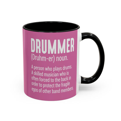 Pink mug with black interior and handle featuring a definition of a drummer on a white background