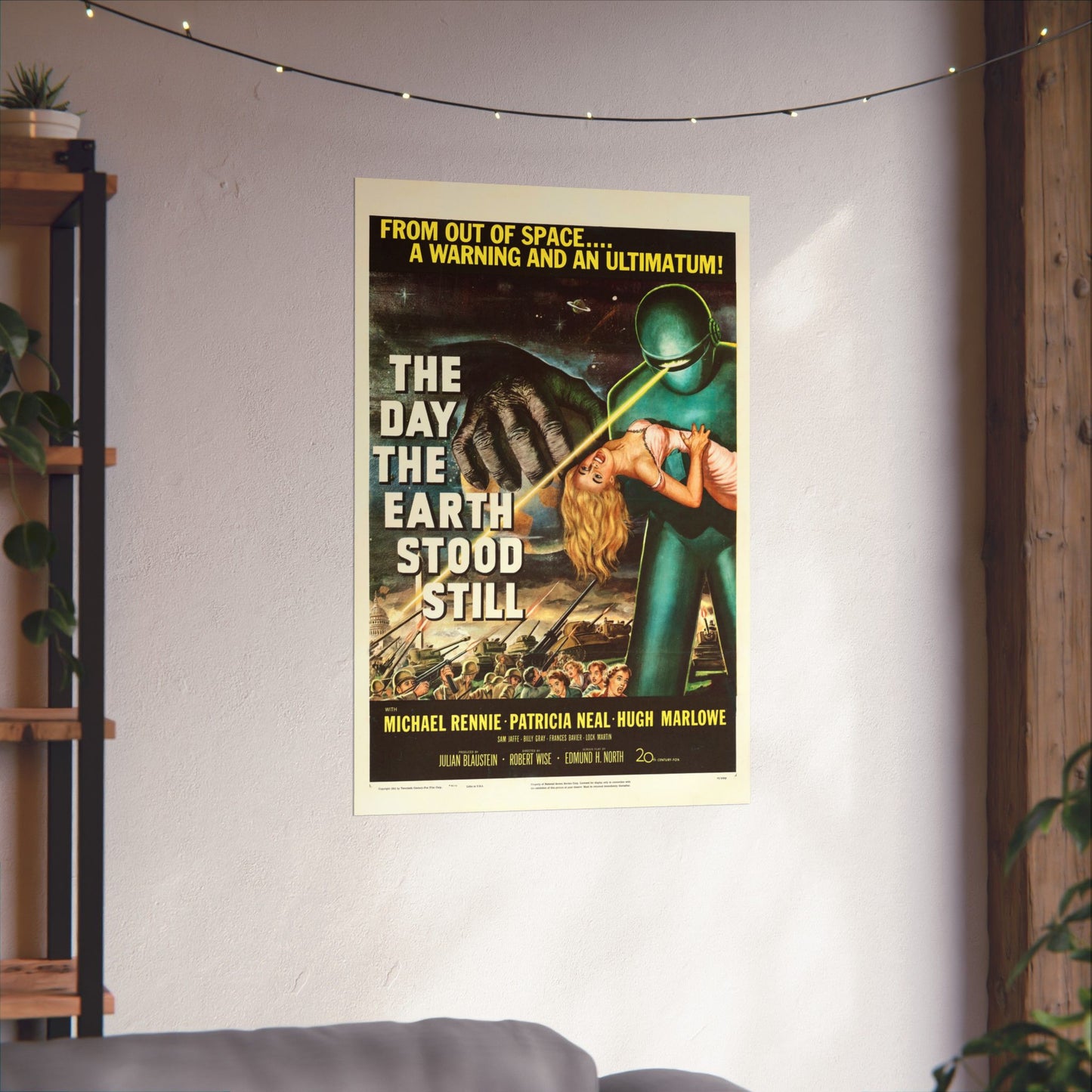 Vintage movie poster for 'The Day the Earth Stood Still' on a wall in a room with plants and a shelf.