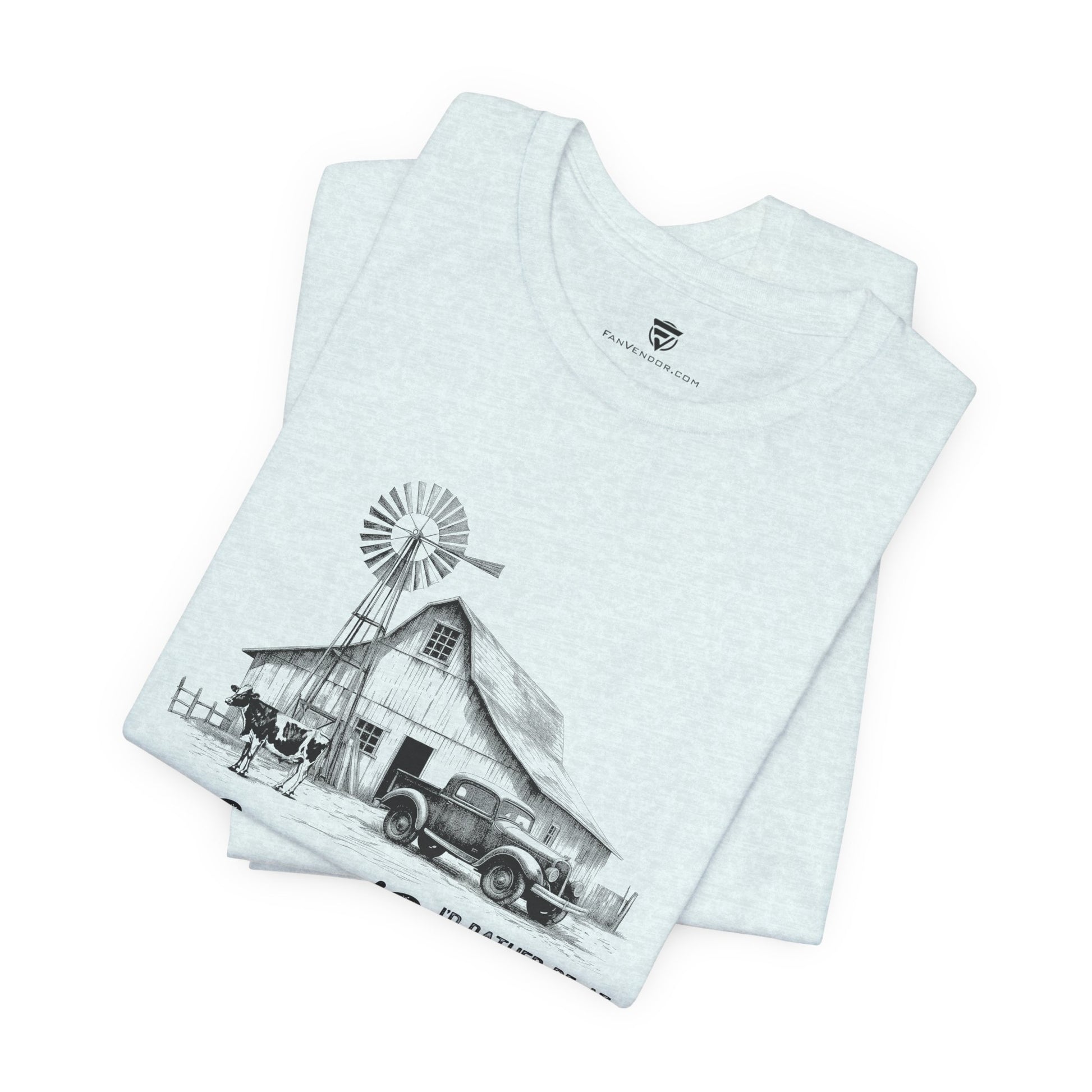 Stack of t-shirts with a graphic design of a barn and windmill 