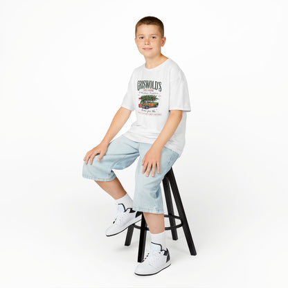 Young boy sitting on a stool wearing a white t-shirt with text and graphics, light blue jeans, and white sneakers.