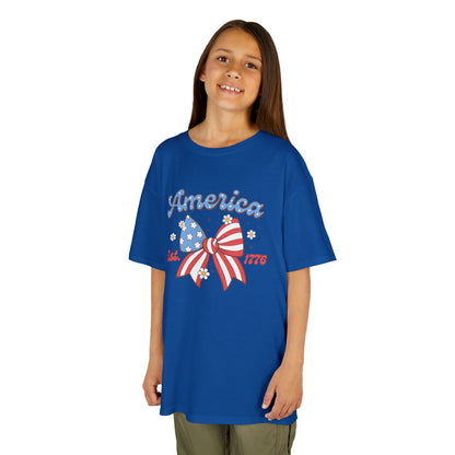 Girl wearing a blue t-shirt with 'America' and a bow design on a white background