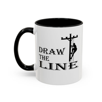 White mug with black handle featuring a silhouette of a person on a power line pole and text 'DRAW THE LINE' on a white background.